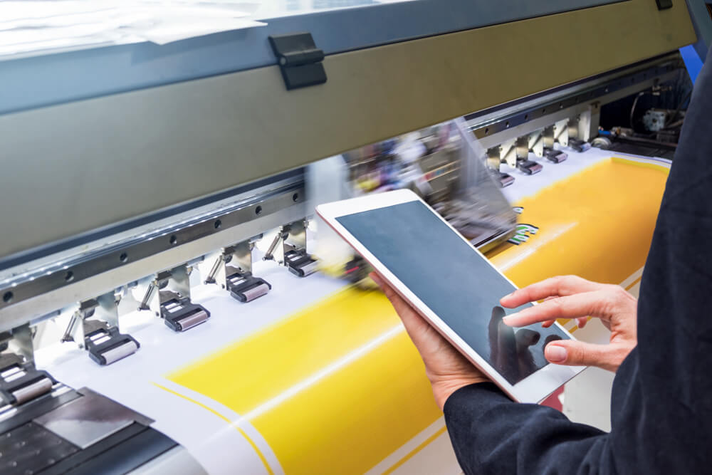 technician-touch-control-tablet-format-inkjet-printer-during-yellow-vinyl