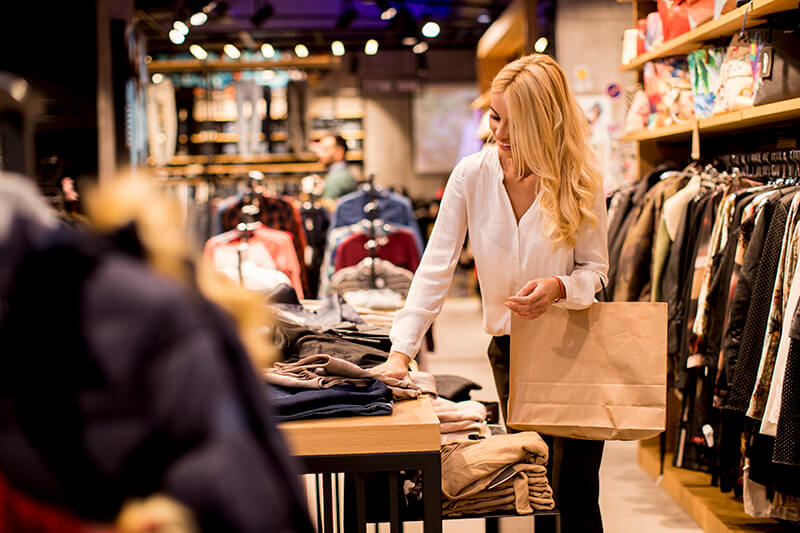 young-woman-with-shopping-bags-standing-clothing-store (1)
